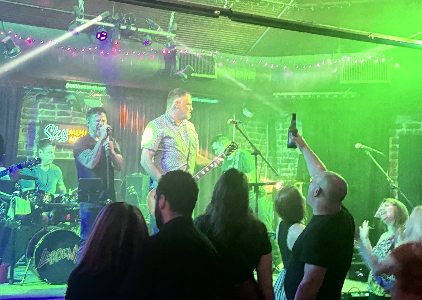 Larceny performing to a packed crowd at Sky Music Lounge with fans cheering