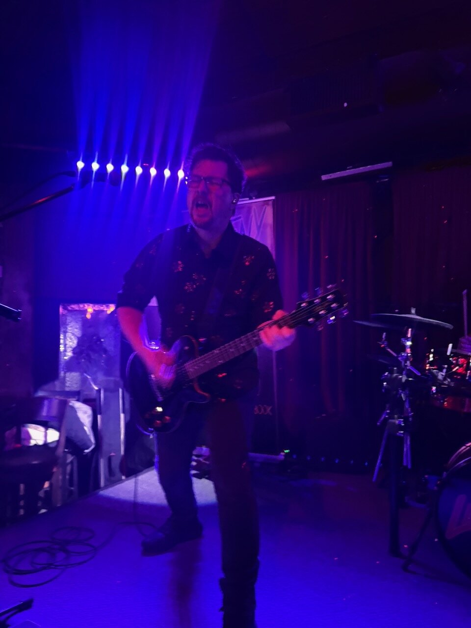 Dan Lastovka rocking out on guitar under purple lights at Sky Music Lounge