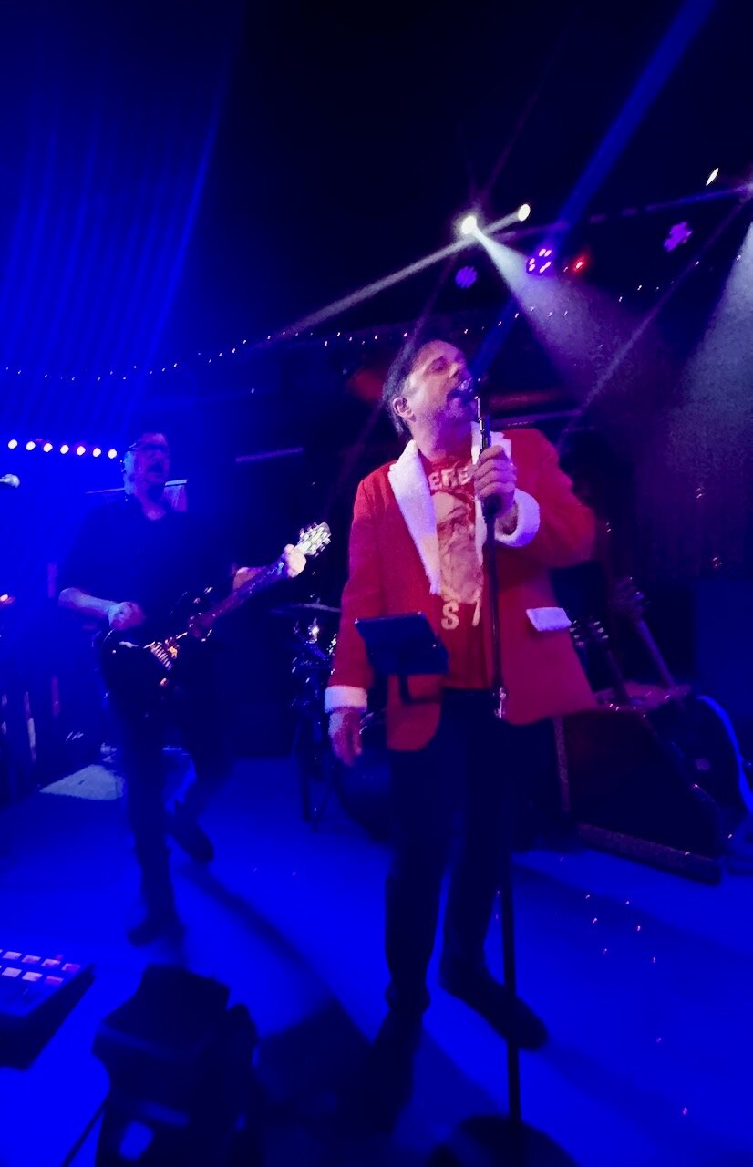 Erik Wilson singing in red jacket at Sky Music Lounge