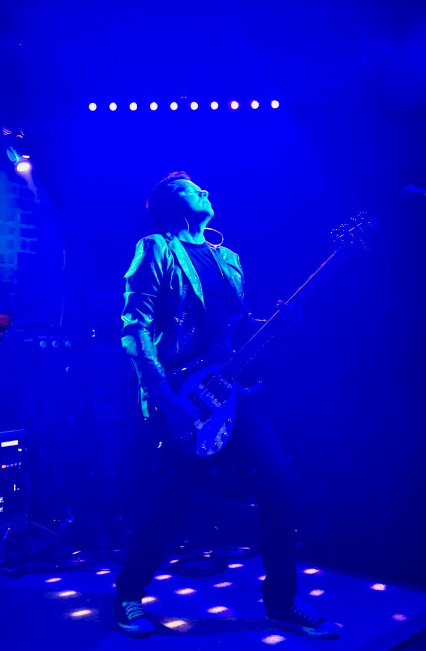 Tim Rooney playing bass bathed in blue light at Sky Music Lounge